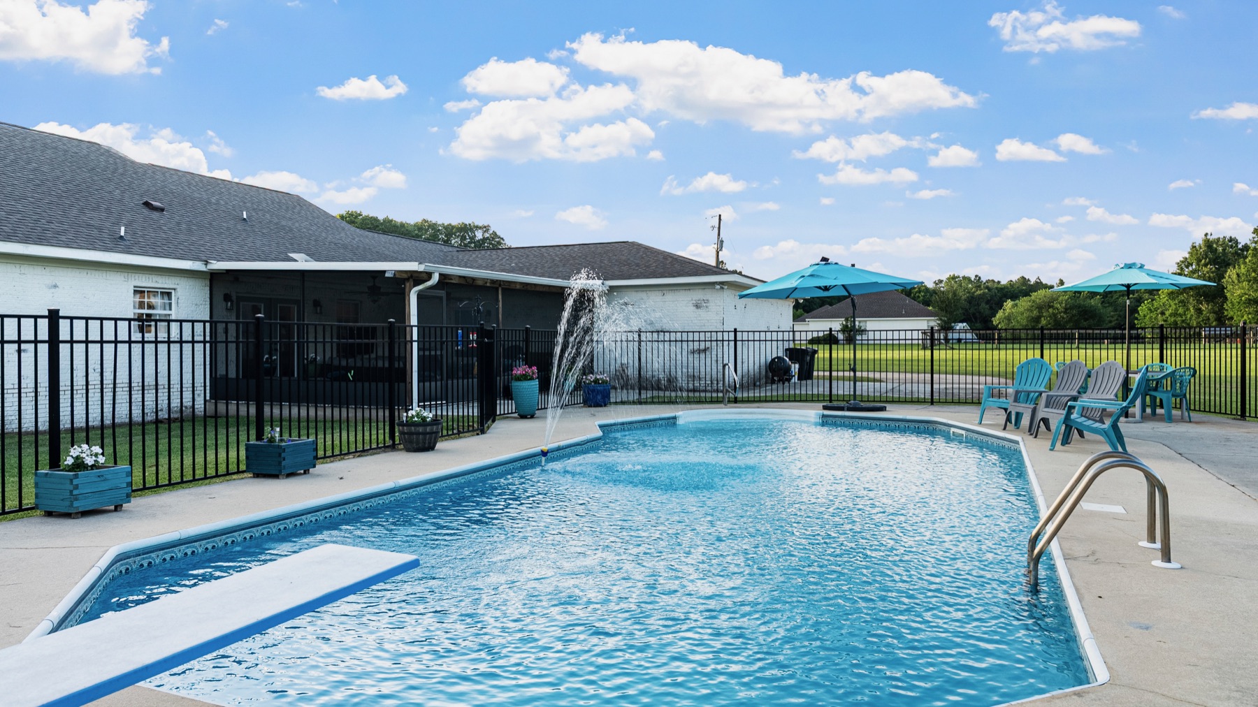 Clean residential swimming pool with a fountain feature serviced by WittCo Pools